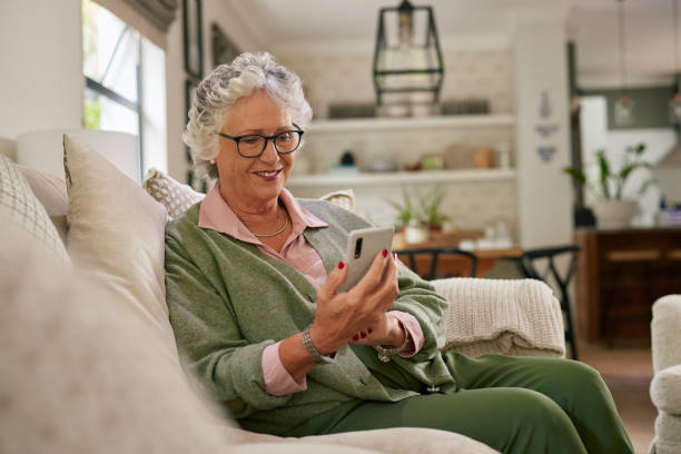 istock Happy senior woman using phone at home 2194051894