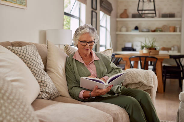 Elder woman reading book on a comfortable sofa