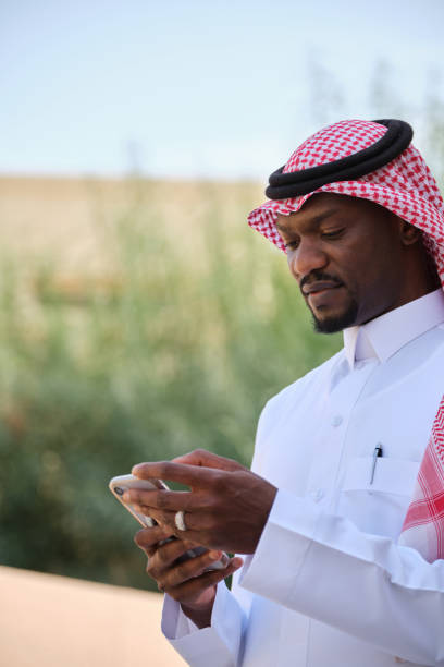 istock Black Arab man wearing a traditional Saudi headscarf and agal using mobile phone 2194052373