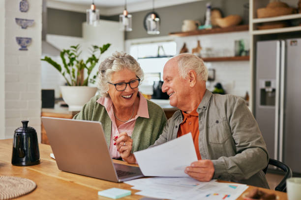 istock Happy old couple managing home finances on laptop 2194052840