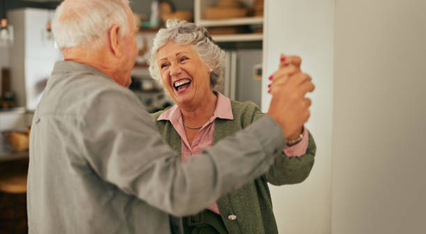 istock Old man dancing with joyful laughing woman at home 2194053087