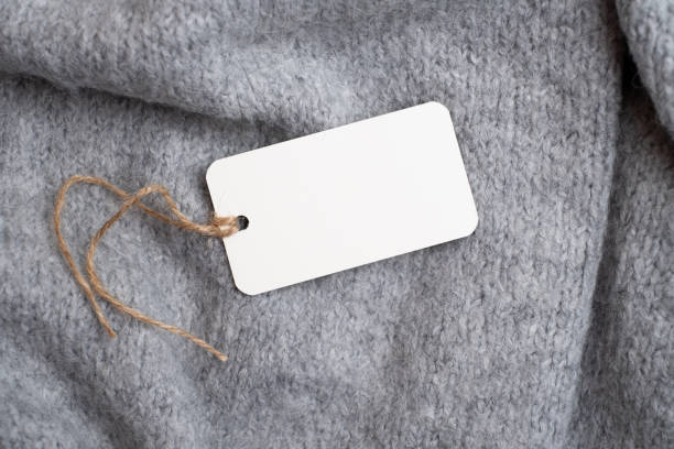 istock Clothes tag on a gray knitted background. Space for text 2194055992