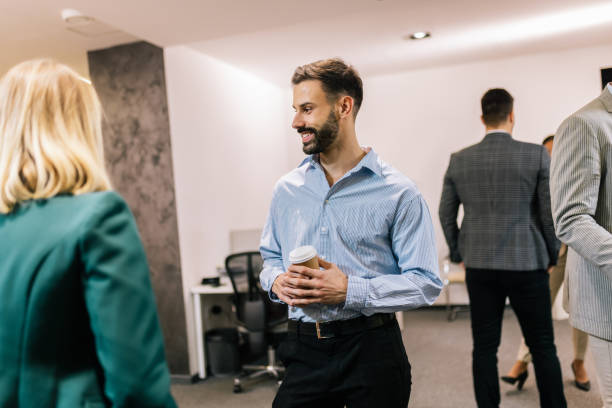 istock Business people on a coffee break during a seminar. Standing in the office and talking about the job. 2194056309