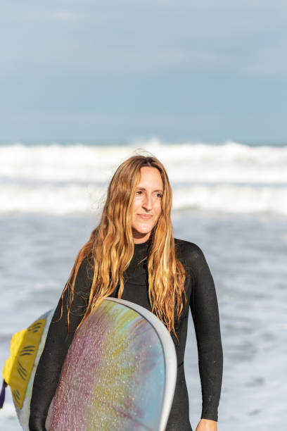 istock Woman with surfboard in sea 2194056910