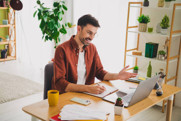 istock Smiling man working at home desk in a modern apartment for productive remote communication 2194059752
