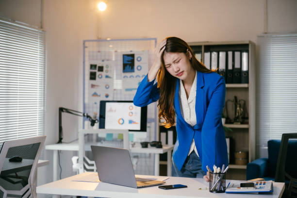 istock Young asian businesswoman feeling tired and stressed from working on a laptop computer, suffering from a bad headache after a long day at work in the office 2194059951