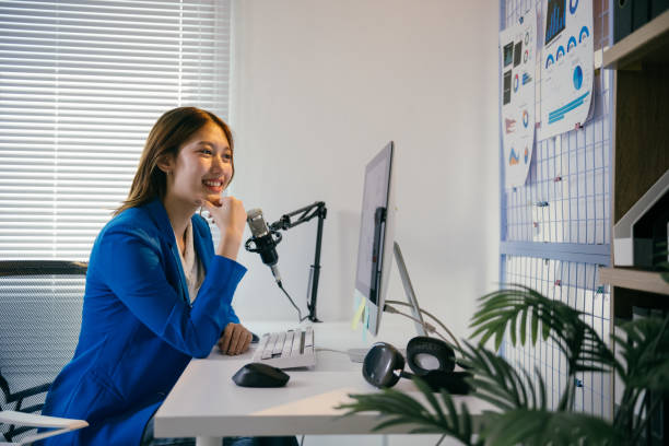 istock Young asian businesswoman recording audio content in her home studio, using a professional microphone and computer while exuding confidence and creativity 2194060123