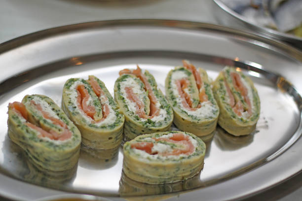 closeup of fingerfood, Salmon rolls in dough with cream cheese, horseradish, spinach and lemon