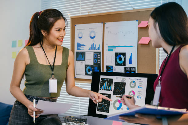 istock Two young asian businesswomen analyzing financial data displayed on a computer screen, pointing at charts and discussing market trends during a collaborative office meeting 2194064465