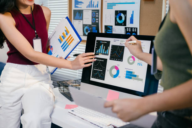 istock Three young businesswomen are collaborating on a project, analyzing financial data displayed on a computer screen and printed reports, pointing at charts and discussing their findings 2194064494