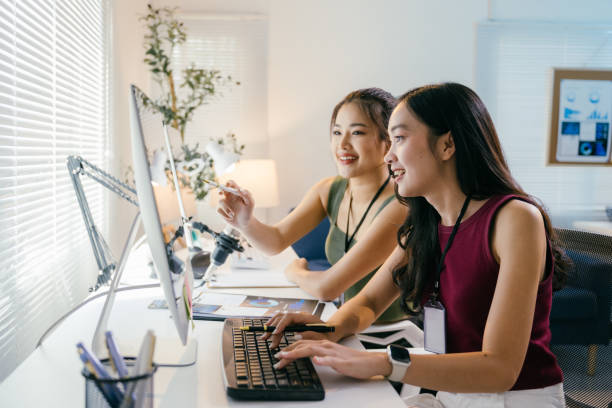 istock Two young asian businesswomen are working together in a modern office, using a desktop computer to collaborate on a project, showing teamwork and dedication 2194064516