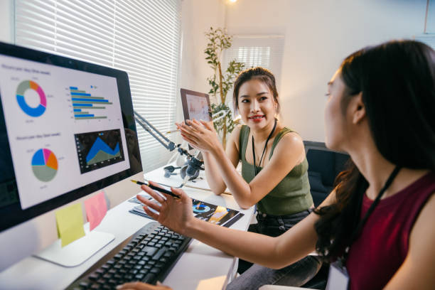 istock Two young asian businesswomen are discussing charts displayed on a computer screen, collaborating on data analysis and business strategies in a modern office setting 2194064523