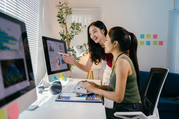 istock Two young businesswomen are collaborating on a project, analyzing charts and graphs displayed on a computer screen in a modern office setting, discussing data and strategizing 2194064856