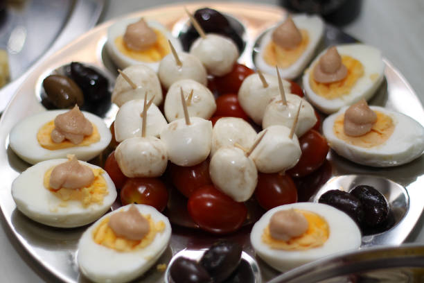close up of finger food with eggs, mozzarella cheese, olives, tomatoes and caviar cream,