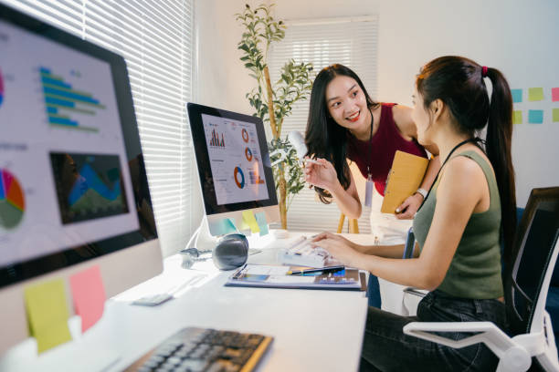 istock Two young businesswomen are discussing charts and graphs displayed on a computer screen, collaborating on data analysis and strategic decision-making in a modern office environment 2194064941