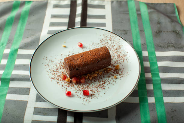 istock Chocolate Potato Cake lying on white plate with pomegranate seeds and nuts, garnished with cocoa powder 2194065862