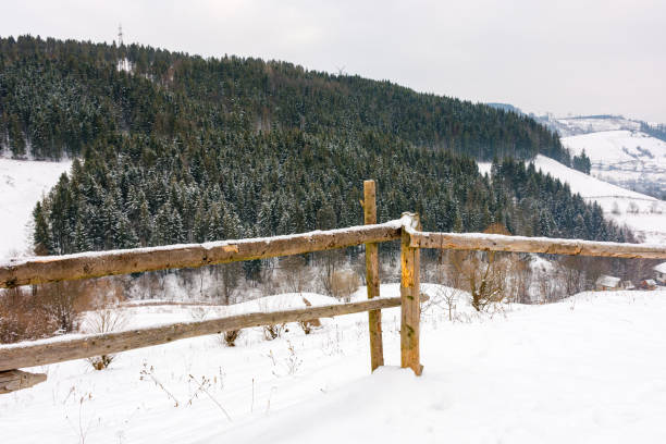 wooden fence on snow covered hill. cold season. mountainous carpathian countryside in winter. wonderful backyard