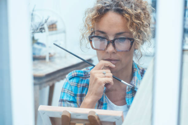 istock Artistic woman painting in a quiet and organized workshop, using professional tools and vibrant colors to create a detailed and expressive piece of art, fully immersed in her creative work 2194068924