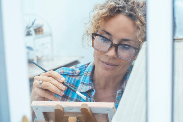 istock Artistic woman painting in a quiet and organized workshop, using professional tools and vibrant colors to create a detailed and expressive piece of art, fully immersed in her creative work 2194068959