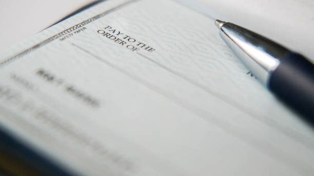 istock Close-Up view of a pen resting on a blank check on a desk 2194070504