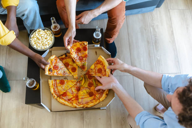 istock Friends sharing pizza and popcorn during casual gathering 2194070862