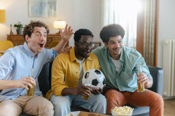 istock Diverse group of young men cheering for their team and drinking beer 2194071304