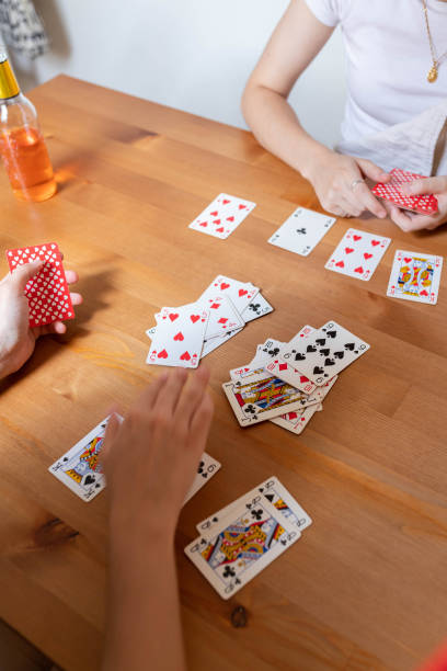 istock Anonymous lesbian couple playing cards at table at home 2194071335