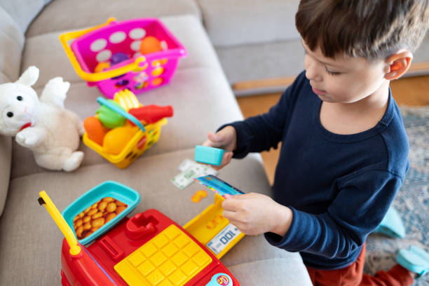 istock A child plays store with a toy cash register. 2194071413