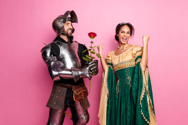 istock Romantic couple dressed as a medieval knight and queen posing with joyful expressions against a vibrant pink backdrop 2194074657