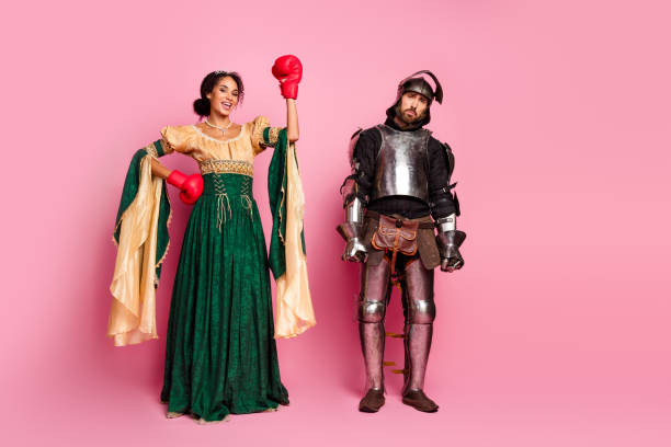 istock Two Costumed Individuals Posing on Pink Background Showcasing Medieval Knight and Royal Theme 2194074759