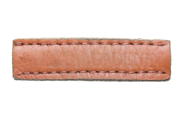 istock Brown leather belt strap closeup isolated on white. Brown stitched leather seam frame label tag isolated on white. 2194074999