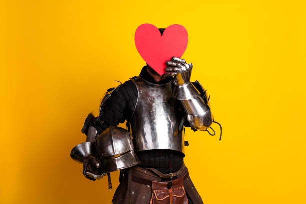 Knight in armor holding a red heart on a yellow background, emphasizing medieval style and modern love concepts