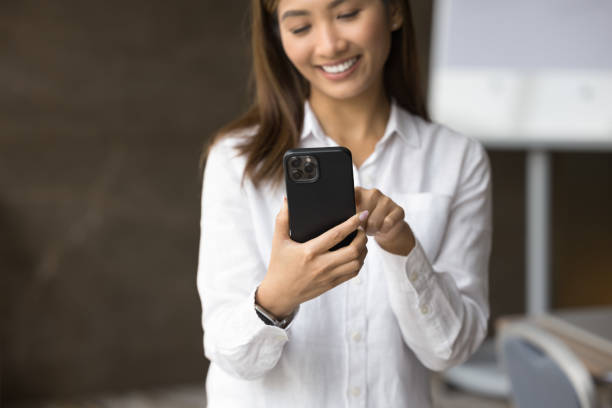istock Close up pretty Asian woman using smartphone in office 2194077643