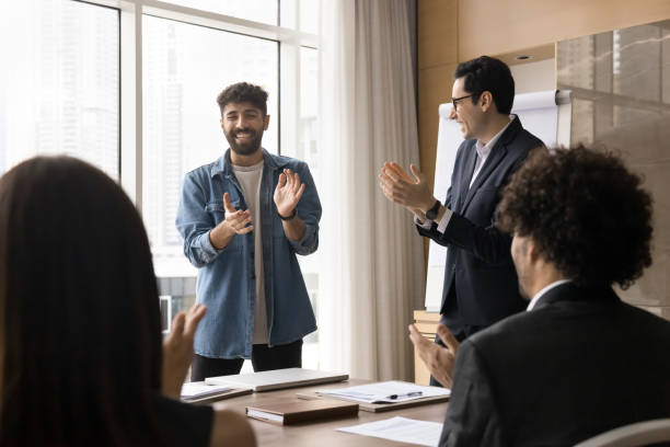 istock Team clapping hands welcoming new company member in boardroom 2194080357