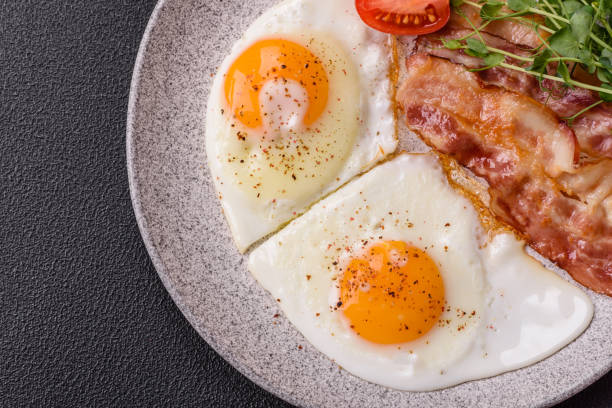 istock A hearty breakfast with fried eggs, bacon, tomatoes, microgreens 2194080437