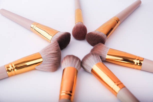 set of decorative brushes and cosmetics on white wooden table