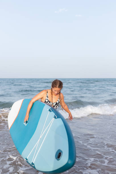 istock Woman with paddleboard near sea 2194082343