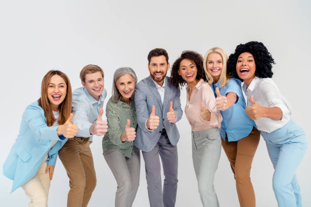 istock Diverse group of professionals showing thumbs up on light background symbolizing teamwork and success 2194086755