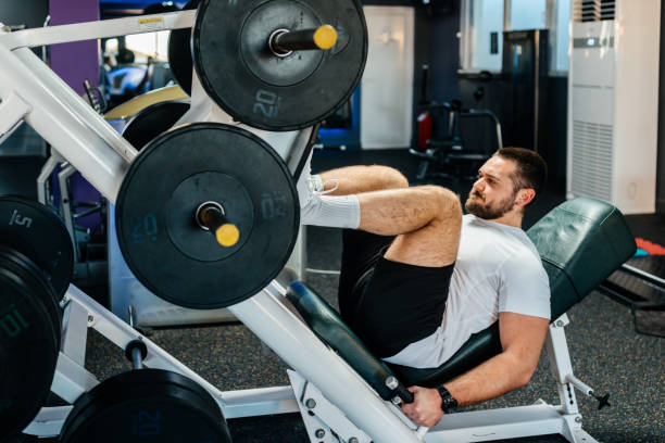 Young woman working out her legs on a leg press machine at the gym, concentrating on building strength and muscle for a fit and healthy lifestyle. Embracing fitness and wellness indoors