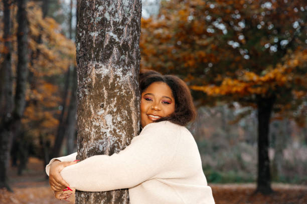 African female adult enjoying autumn in forest with colorful leaves