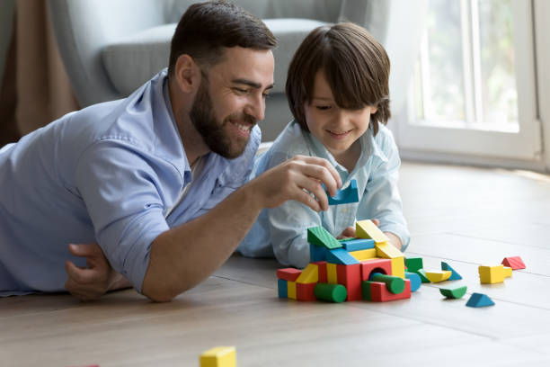 istock Happy dad teaching cute son kid to build toy forecast 2194093825