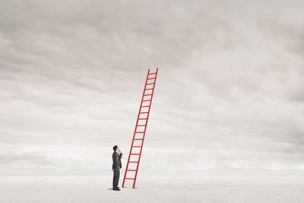 istock Man Looks At Ladder Leading To Nowhere 2194094330