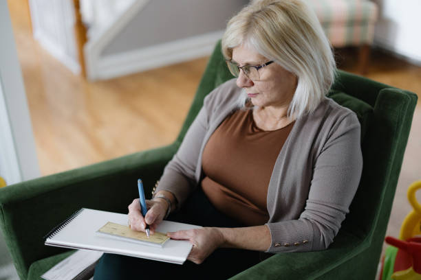istock Focused Woman Working on Papers in a Home Kitchen Environment 2194095210