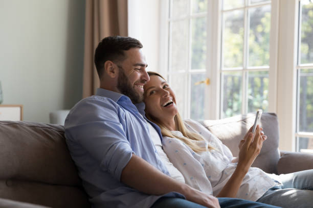 istock Happy cheerful married couple relaxing, hugging on couch at home 2194096287