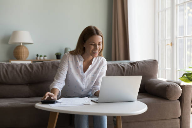 istock Happy cheerful millennial woman using laptop and calculator 2194097153