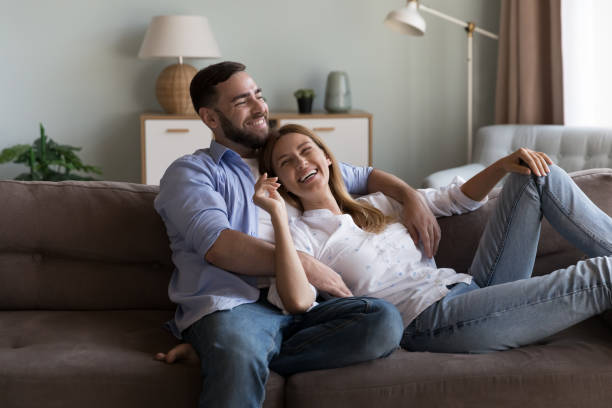 istock Cheerful dreamy married couple enjoying leisure on sofa 2194097710