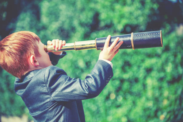 istock A child in a business suit looking through a telescope 2194098030