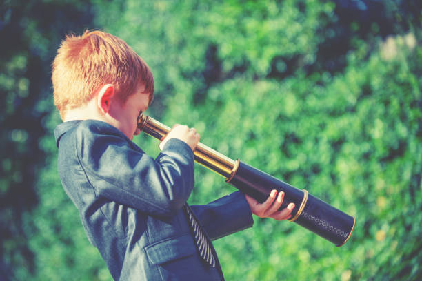 istock A child in a business suit looking through a telescope 2194098072
