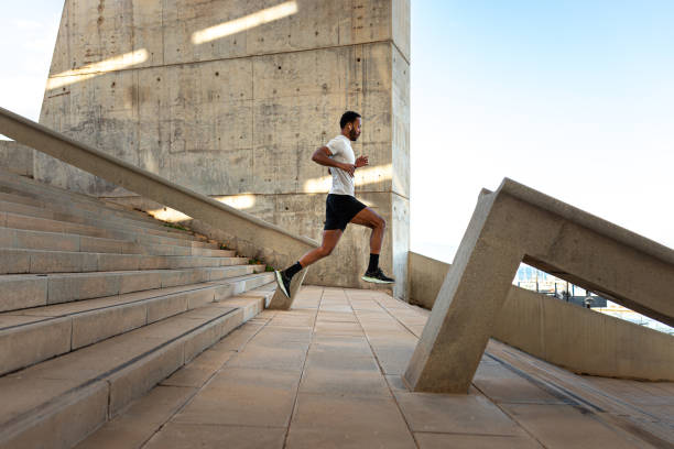 Young male athlete running and jumping on urban concrete steps