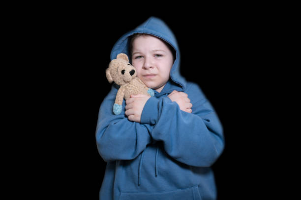 istock Girl with a teddy bear in the dark 2194099615
